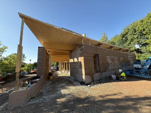 wood roof stretches over rammed earth structure