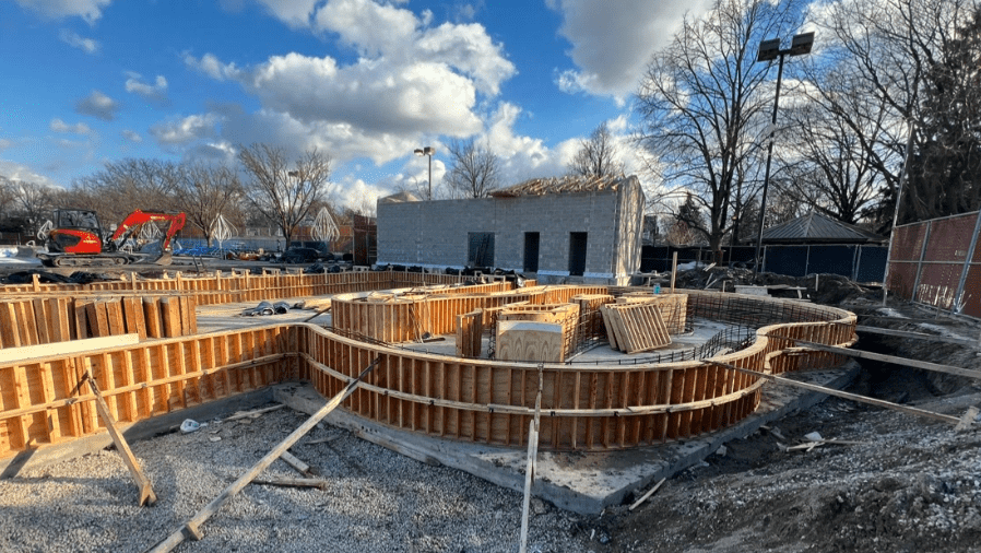 Construction of Rehm Park & Pool shows concrete forms for a pool and a cinder block building under construction.