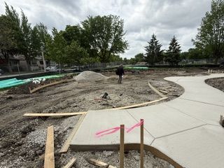 Construction of new pathways and landscaping at Longfellow Park. A person walks in the distance.