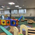Colorful indoor playground with slides, tunnels, climbing blocks, and soft play structures for children.